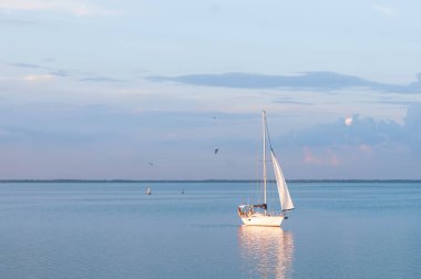 Cherkasy, Ukrayna-07.20.2018: tekne yelkenleri görünümü ve mavi gökyüzünde turuncu parlayan yansıma çevirir