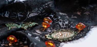 turuncu boncuk, dekoratif yeşil kelebek, çerçeve ve kopya alanı ile beyaz arka planda Rhinestones ile siyah dantel yakın