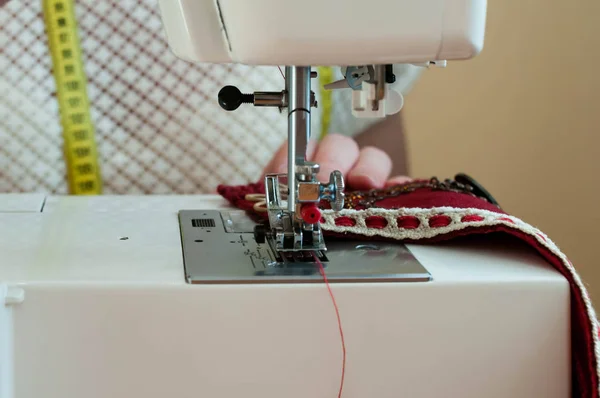 Сшивание Рук Швеями Помощью Швейной Машинки Красная Ткань Деревянной Поверхности — стоковое фото
