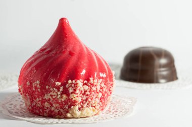 Beyaz arka plan üzerinde kahverengi çerez önünde kağıt peçete üzerinde kırmızı pastadan seçilen odak