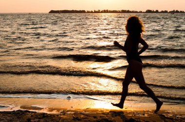 güneşin doğuşunda büyük nehir kıyısında çalışan mayo kadının karanlık silüetinin yan görünümü