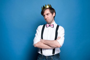 gömlek, askı, Bow kravat ve altın taç üzgün yakışıklı adam uzak kopya alanı ile mavi arka planda bakıyor