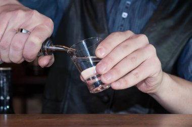 çubukta cam içine şişe alkol içecek dökme karşı barmen kırpılmış görünümü