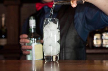 çubukta buz ile cam içine alkol içme karşı barmen kırpılmış görünümü 