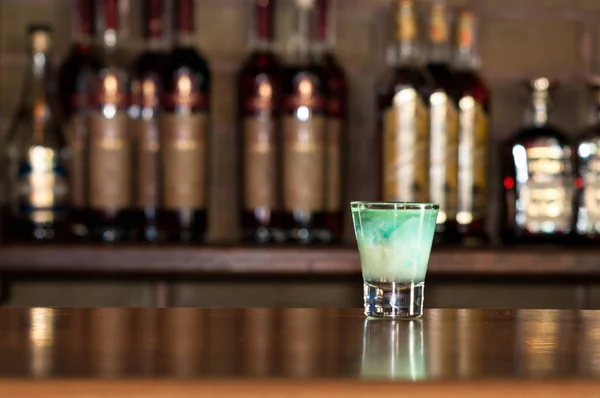 チェルカースィ ウクライナ Palatin レストラン 2019 バーの背景にボトルと木製のカウンターの上にクリアショットガラスで青アルコール飲料の選択的焦点 — ストック写真