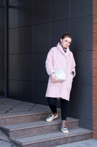 Woman Pink Coat Black Pants Standing Stairs Grey Wall Looking — 스톡 사진