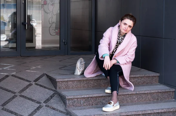 Woman Pink Coat Black Pants Sitting Grey Stairs Looking Camera — ストック写真