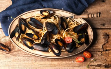 domates soslu lezzetli makarna üst görünümü ve metal plaka ve ahşap dokusal arka plan kabukları pişmiş midye