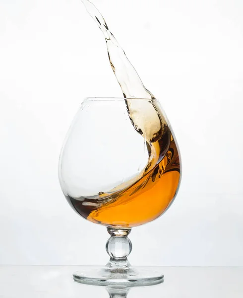 Splash Van Cognac Kristal Glas Grijze Achtergrond Met Reflectie — Stockfoto