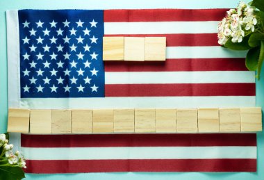 mavi arka plan üzerinde Amerikan bayrağı üzerine serilmiş on beş ahşap küpler üzerinde yazıt için boş üst görünümü