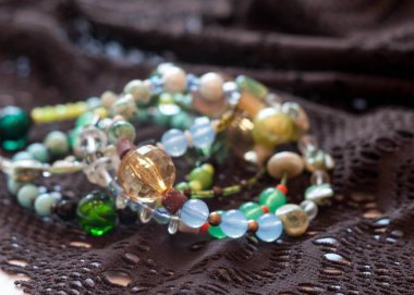 koyu kahverengi dantel arka plan üzerinde çok renkli boncuklar ile bilezik