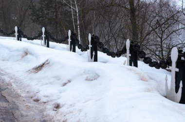 Güzel kar manzaralı ağaçlar ve yerde bir sürü kar, kışın parktaki gri gökyüzü.
