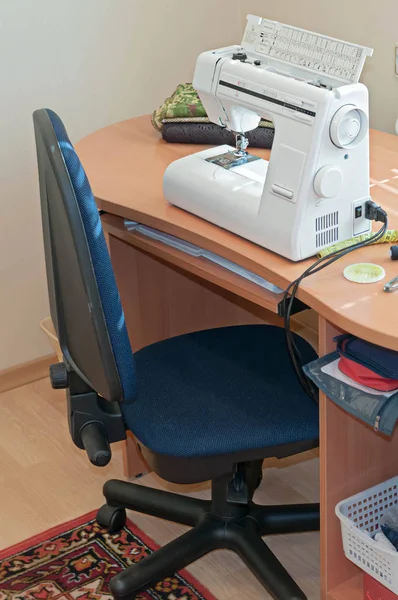 白色缝纫机 木桌上的织物折叠和缝纫室的蓝色椅子 — 图库照片