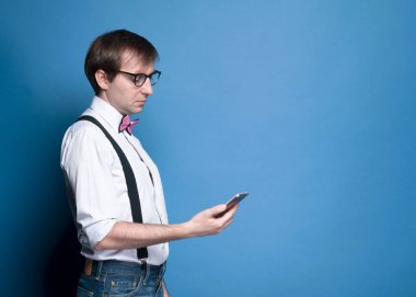 Stüdyo geçmişinde akıllı telefonu olan genç yakışıklı bir adam.