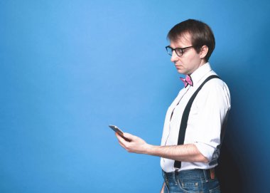 Stüdyo geçmişinde akıllı telefonu olan genç yakışıklı bir adam.