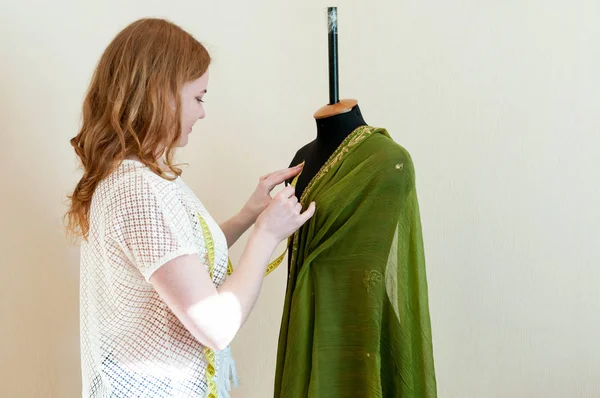 裁缝师站在壁炉架附近 在裁缝店用绿色布工作的侧视图 — 图库照片