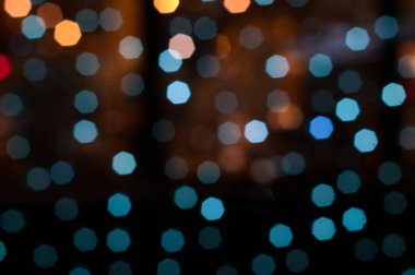 Odaklanmış bulanık parlak parlak noeller beyaz, mavi ve turuncu ışıklar duvar kağıdı için koyu renk.