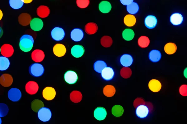unfocused blurred colorful lights on black background for wallpaper and copyspace