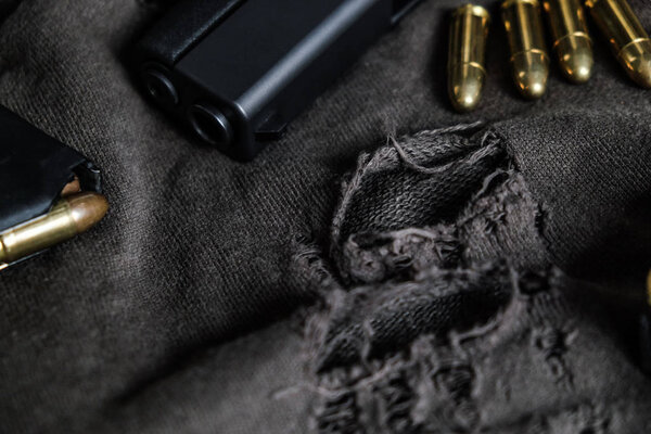 9mm semi autometic hand gun with FMJ bullet on fabric, Crime concept