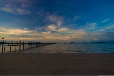 Deniz kıyısındaki ahşap köprü. Gün doğumu. Renkli gökyüzü.