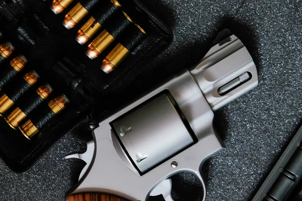 Metal revolver .44 magnum pistol gun with jacket soft point(JSP) bullet on dark background