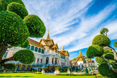 Grand palace in emerald buddhist temple green grass tree field sightseeing travel in Bangkok, Thailand clipart