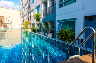 Düşük katlı apartman binasının içinde lüks gümbürtü havuzu, Emlak endüstrisi