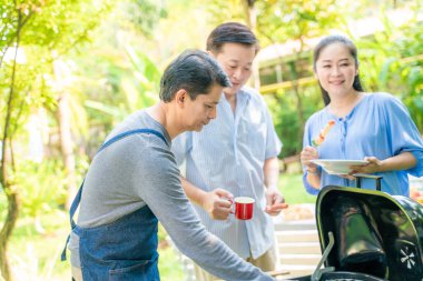 Olgun orta yaşlı grubunuz barbekü yemek yeşil Park'ta parti piknik