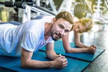 Kadınlarla tahta konumda spor yapan spor etkin beyaz erkek portresi