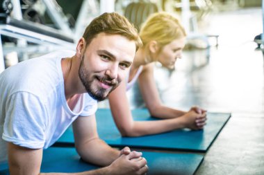 Kadınlarla tahta konumda spor yapan spor etkin beyaz erkek portresi