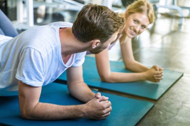 Kadınlarla tahta konumda spor yapan spor etkin beyaz erkek portresi