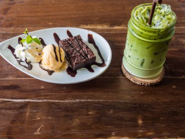 Ahşap masada tatlı ve buz yeşili süt çayı ile dondurma, gıda ve içme