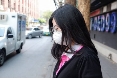 Kadın, sokakta hava kirliliği acı koruyucu maske N95 giyen şehirde hava kirliliği