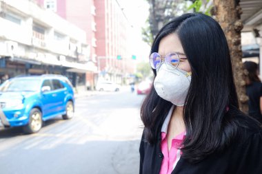 Kadın, sokakta hava kirliliği acı koruyucu maske N95 giyen şehirde hava kirliliği