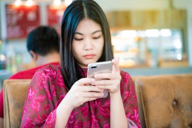 Divan grubu smartphone arka plan kullanarak kafede oturan kadın