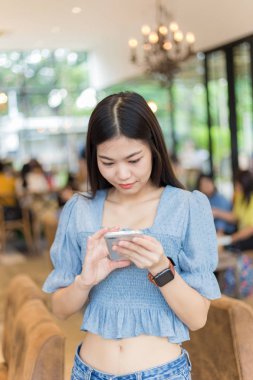 Genç güzel akıllı cep telefonu finans, iş, online alışveriş için kafede kullanan kadın internet bankacılığı. bulanık insanlar arka plan