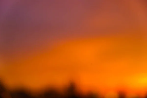 Niewyraźne miasto zachód słońca budynku kolorowe niebo — Zdjęcie stockowe