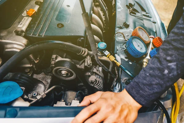 Mechanic check car air conditioner system in garage