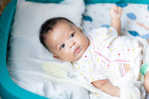 Infant baby boy vomit after eat milk on bed