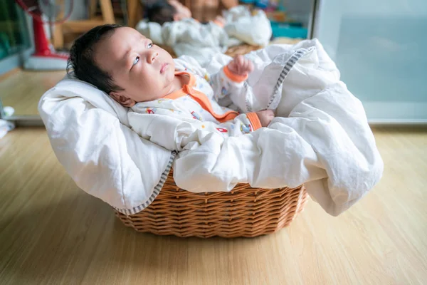 Schattig baby jongetje liggend in mand met witte deken — Stockfoto