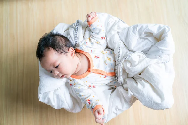 Adorable bebé niño acostado en la cesta con manta blanca — Foto de Stock