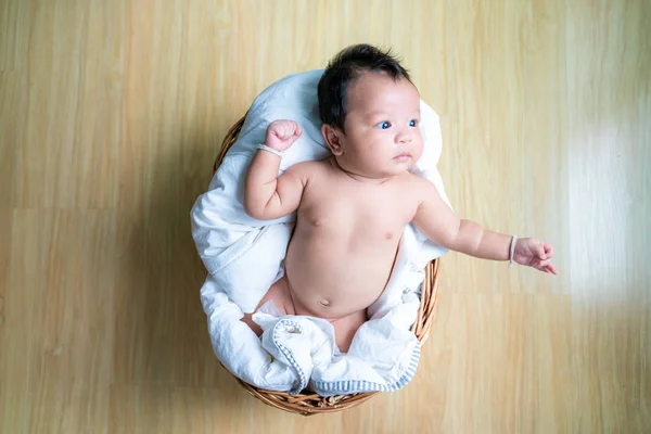 Baby infant boy lying on wood basket top view — Stock Photo, Image