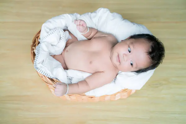 Baby infant boy lying on wood basket top view — Stock Photo, Image