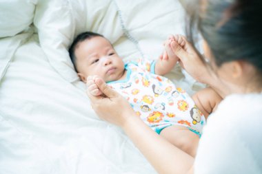 Battaniye üzerinde bebek bebek ile oynayan anne