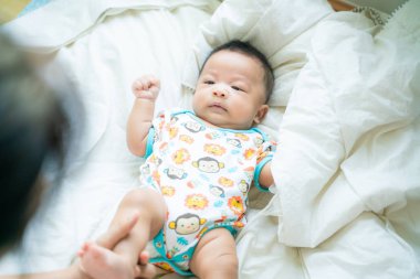 Battaniye üzerinde bebek bebek ile oynayan anne