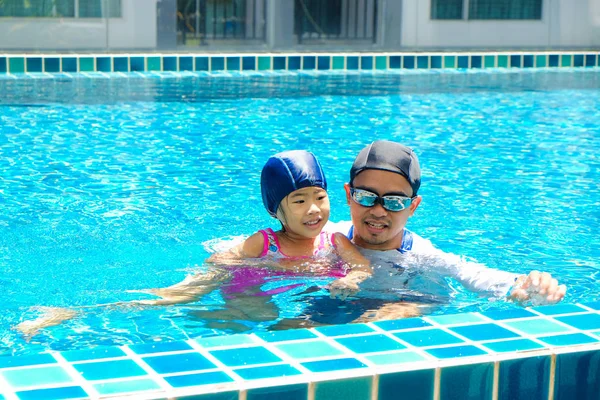 Far undervisning dotter simning i poolen — Stockfoto