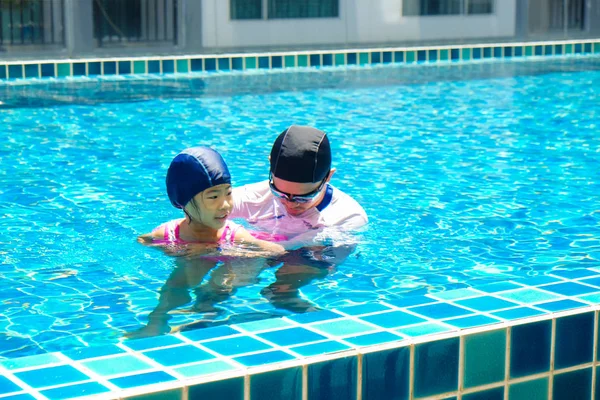 Padre enseñando a hija a nadar en piscina —  Fotos de Stock
