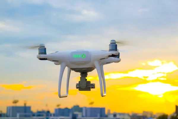 Dron UAV volando sobre la ciudad edificio colorido atardecer —  Fotos de Stock