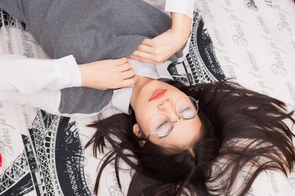 Gafas de mujer relajarse acostado en la cama — Foto de Stock