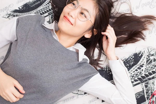 Очки женщины расслабляются лежа на кровати — стоковое фото